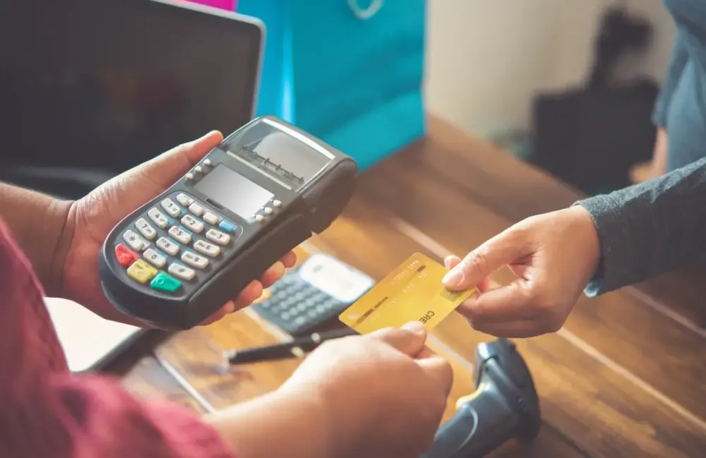 a man hand holding a pos device and a customer gives his credit card